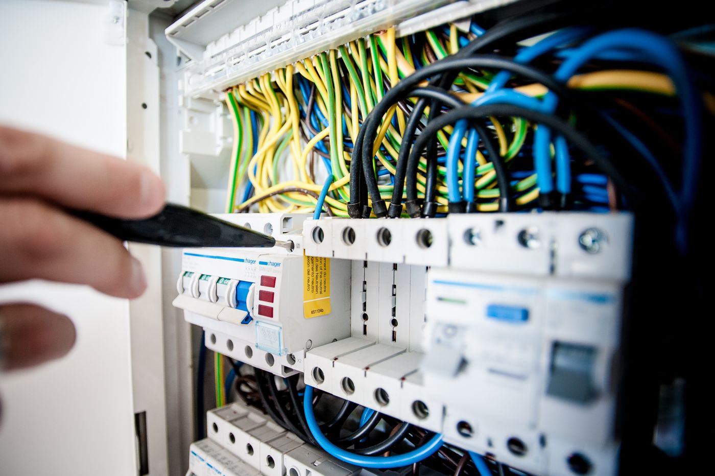 Electrician fixing an opened switchboard